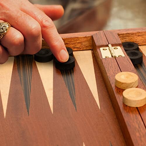 Hand moving a piece on a backgammon board