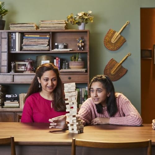 Two people playing Jenga at a table.