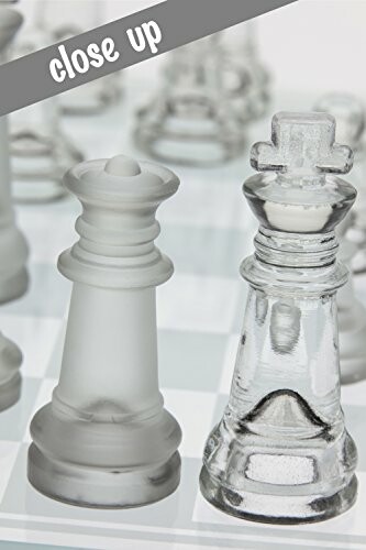 Close-up of frosted and clear glass chess pieces on a board.