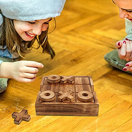 Children playing wooden tic-tac-toe game on floor